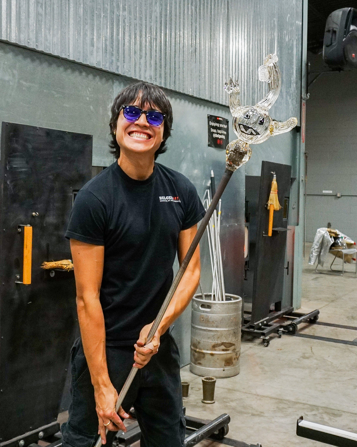 Santiago Mora holding glass piece of art during glassblowing demo at October's First Friday at the Belger Glass Annex in Kansas City